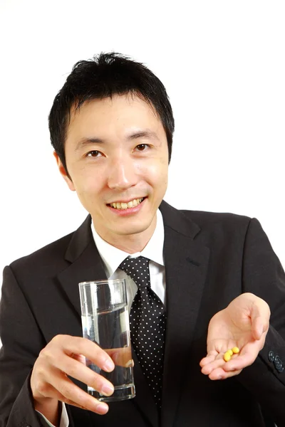 Japanese Businessman takes supplement　 — Fotografia de Stock